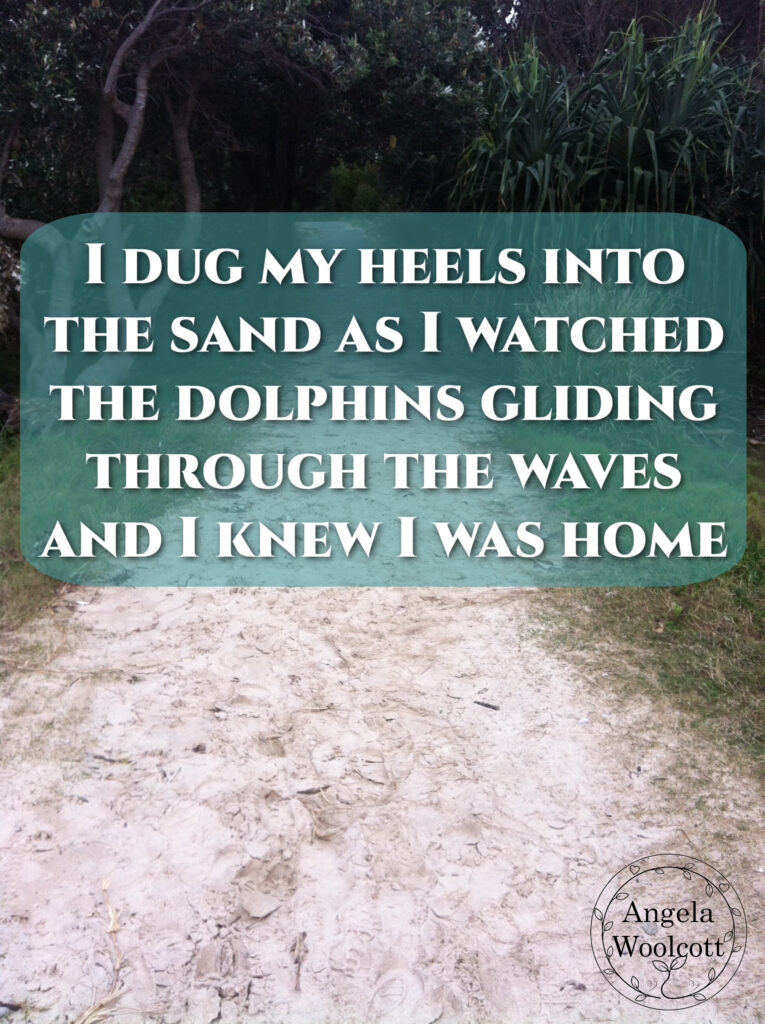 A sandy track leading up the hill with trees and grass either side with a positive quote.