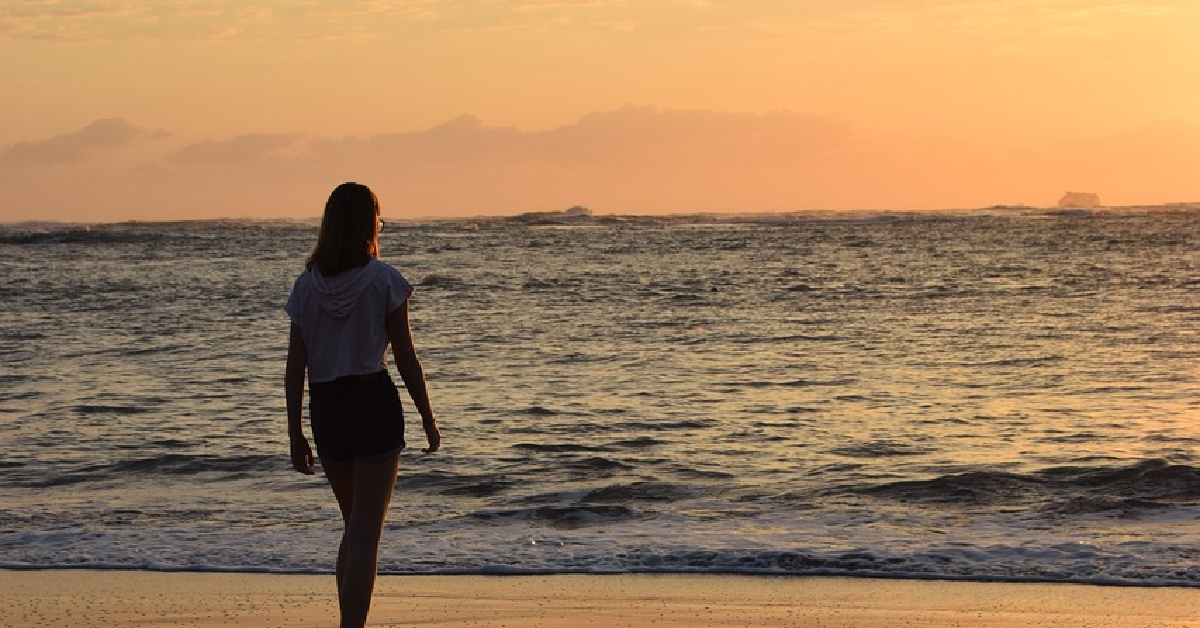 back of woman beach featured