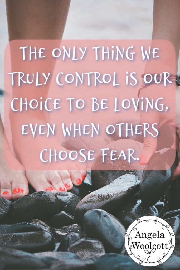Woman picking up rocks off the beach with positive quote.