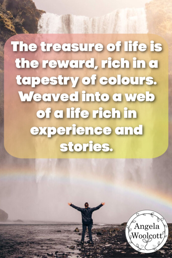 Person underneath a waterfall with a rainbow above it.