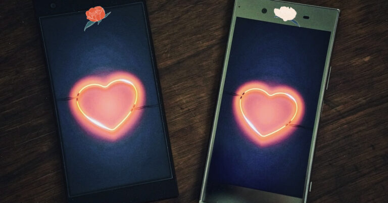 Two mobile phones with love hearts on them and flowers.