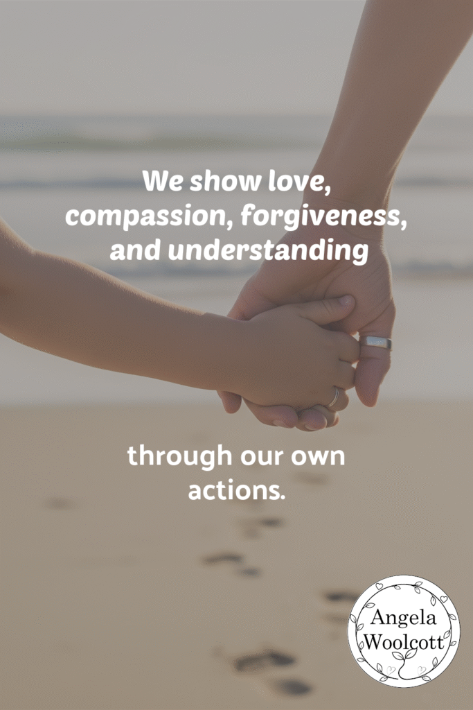 This image shows an adult's hand and a child's hand holding hands while walking toward a beach. Quote: We show love, compassion, forgiveness, and understanding through our own actions.
