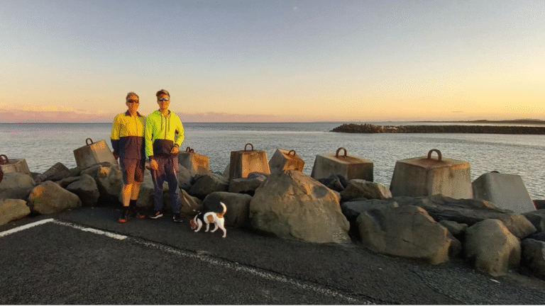 Brad and Toby Woolcott on Ballina North Wall 2023, river in the background. Jack Russel on a lead.